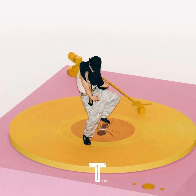 Person dances on a yellow turntable with a pink base against a white backdrop, creating a playful and dynamic visual for music-related content.