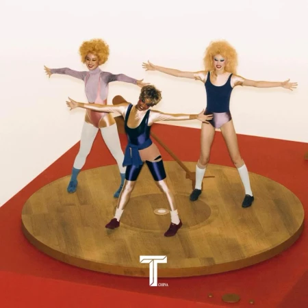Three performers in retro workout attire strike a pose atop a vinyl record player against a neutral backdrop. Vibrant colors and playful style.