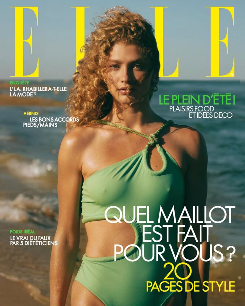 Elle magazine cover featuring a blonde woman in a green swimsuit on a beach with the ocean and blue sky in the background.