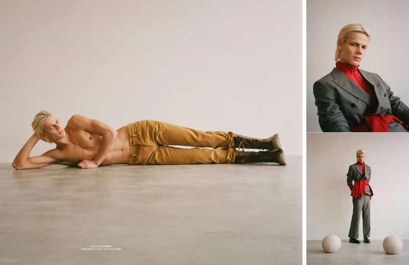 Male fashion model poses in a photo studio. He is lying shirtless in tan trousers and boots. A second image shows him dressed in a suit.