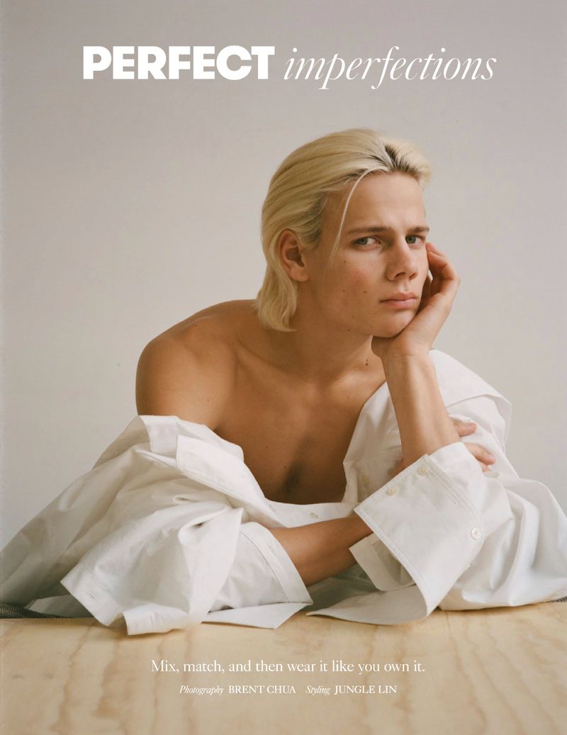 Portrait of a young adult with blond hair in a white collared shirt, resting their head on their hand, with text overlay.