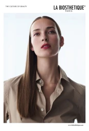 Model Julia Bergshoeff with sleek straight brown hair wearing a beige buttoned shirt against a bright white background.