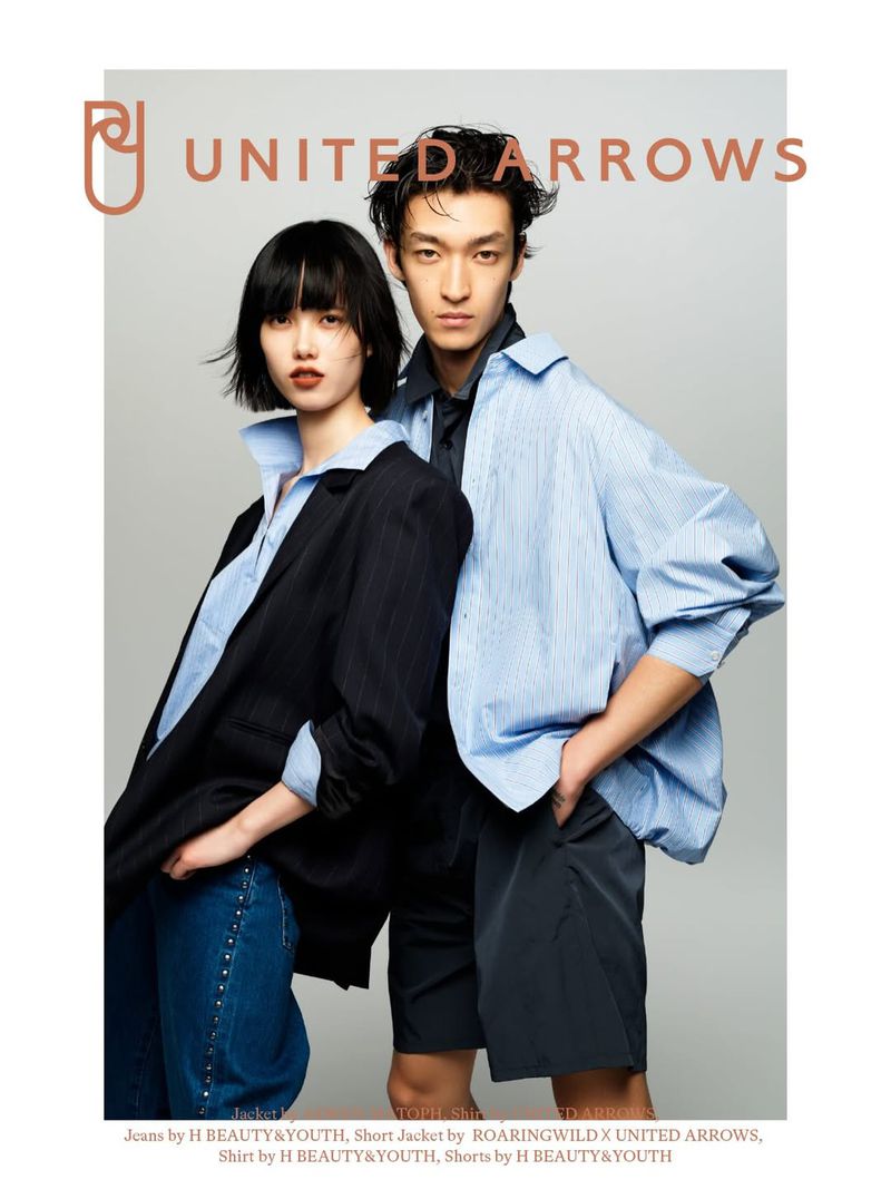 Two models wearing layered button-down shirts and jackets against a seamless grey backdrop in a campaign image for United Arrows