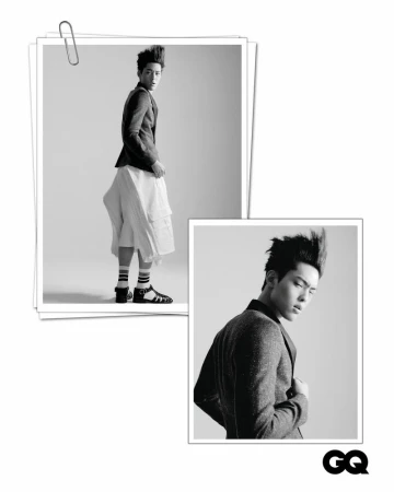 Black and white fashion portrait of an adult male model wearing a blazer and culottes in a photo studio pinned to paper.