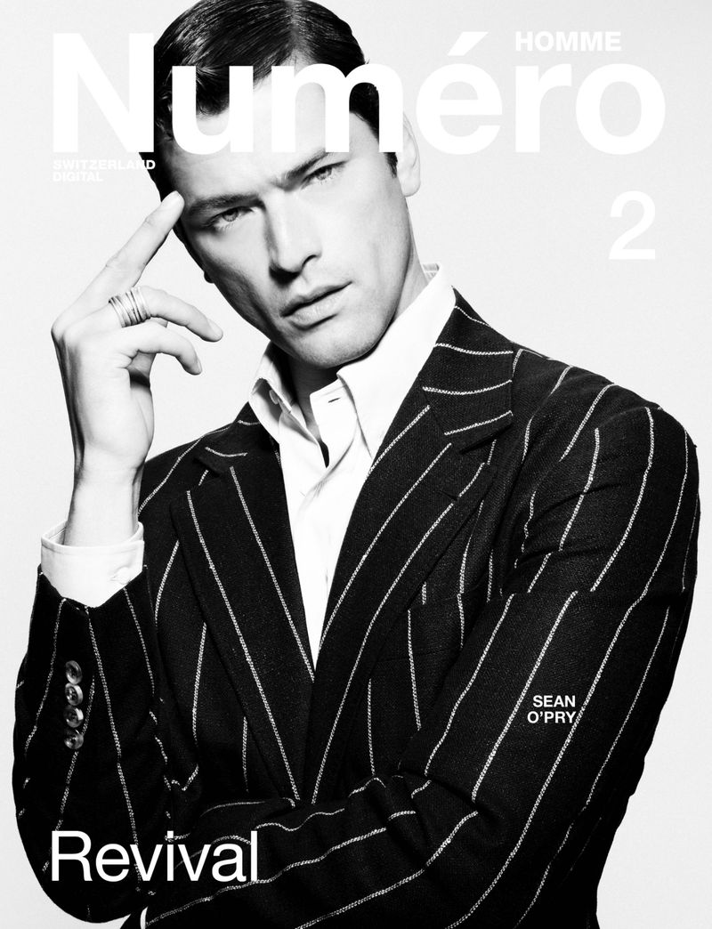 Male model Sean O'Pry poses in a pinstripe suit on a fashion magazine cover with white text. Black-and-white fashion editorial.