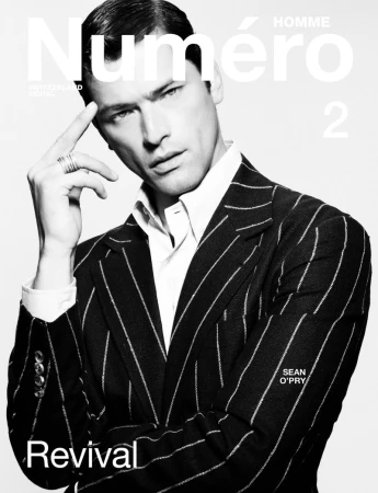 Male model Sean O'Pry poses in a pinstripe suit on a fashion magazine cover with white text. Black-and-white fashion editorial.