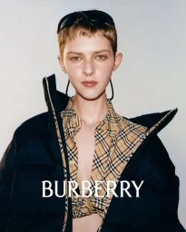 Model wearing a black puffer jacket and a beige plaid shirt against a light background with Burberry text overlay