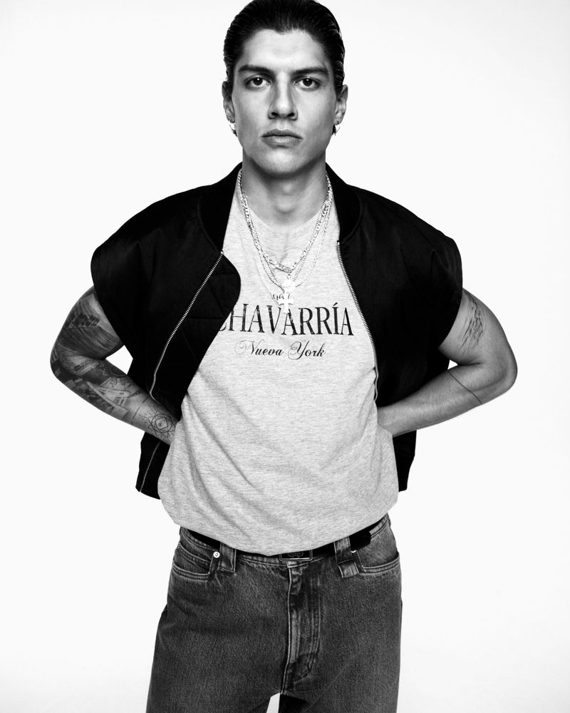 Monochrome portrait of Alberto Guerra wearing a grey graphic t-shirt and black jacket against a plain white background