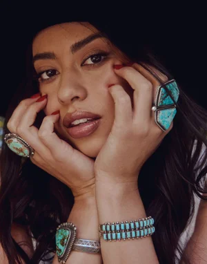 Close-up portrait of Amber Midthunder wearing large turquoise rings and silver bracelets for Grumpy Magazine