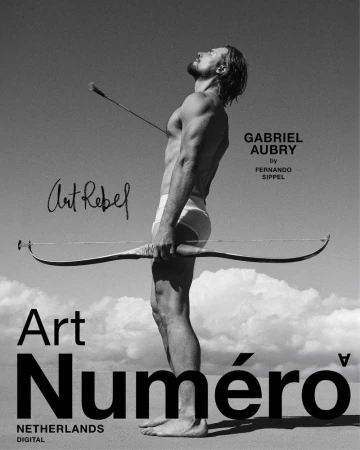Gabriel Aubry holding a bow outdoors against a sky background in a black and white editorial portrait photograph