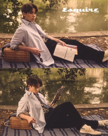 An Asian man sits on a striped picnic blanket by a pond, reading and relaxing, dressed in a striped shirt, for a stylish outdoor fashion editorial.