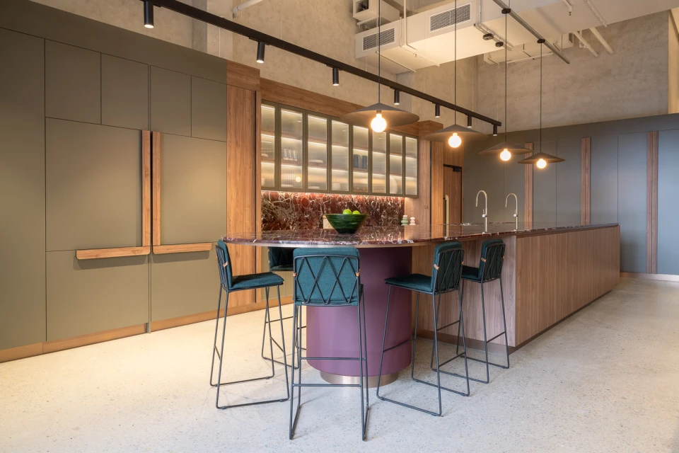 Interior design featuring a kitchen island with bar stools, pendant lighting, and stylish cabinets in a modern indoor setting. 