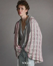 Model Jesi Evans wearing striped shirt and textured knit cardigan against a grey backdrop for Vogue Thailand