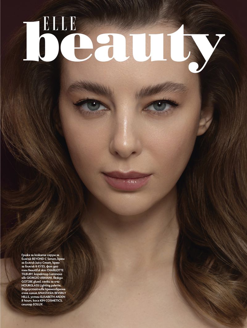 Close-up beauty shot of an adult female with light skin, brown hair, and blue eyes, as featured on the cover of ELLE Beauty magazine.