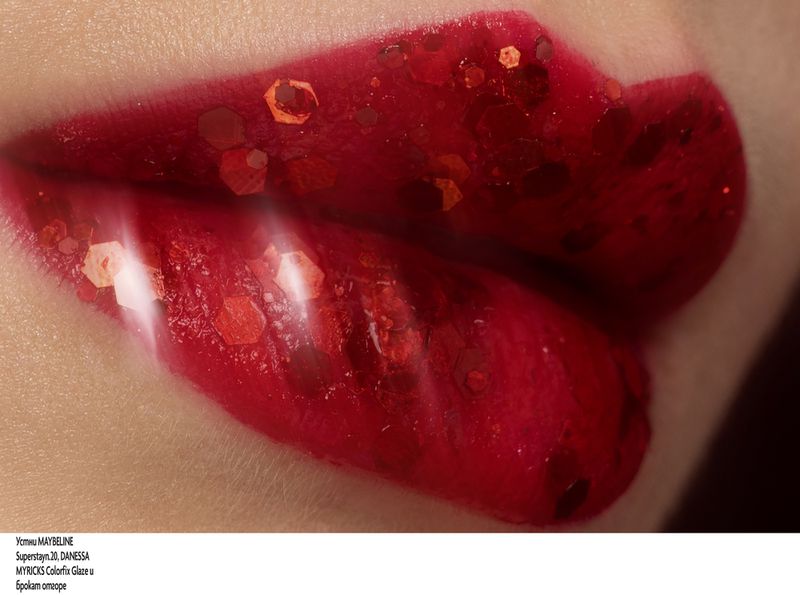 Close-up of a woman's lips covered in red lipstick and glitter with a blurred effect, beauty shot.