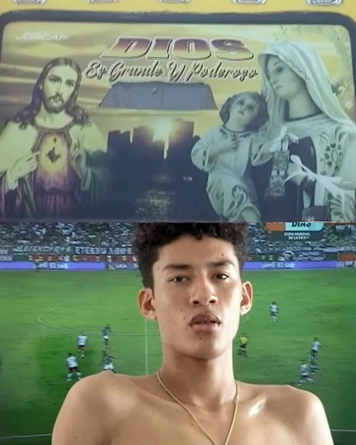 Young adult shirtless man poses in front of a television screen showing a soccer game and a religious illustration. 