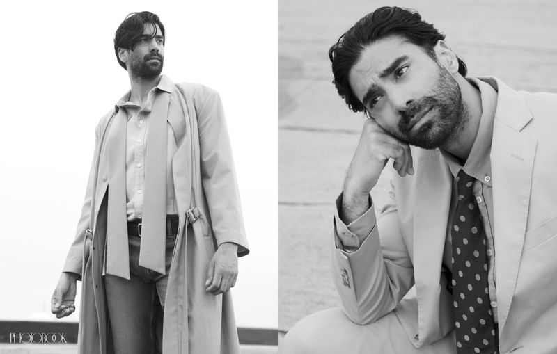 Black and white portrait featuring a man in a suit and trench coat, showcasing a classic, editorial style with shallow depth of field.