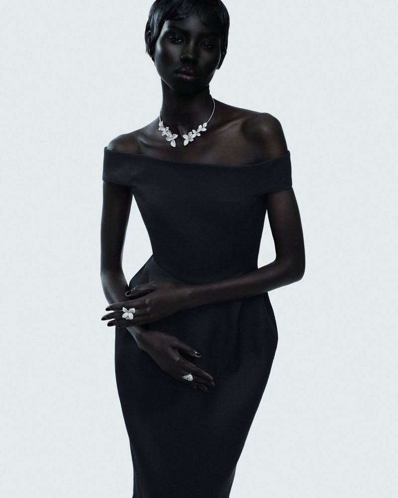Model Nyanderi Deng wearing a black off-the-shoulder dress and diamond jewellery against a white backdrop for L'Officiel Italia.