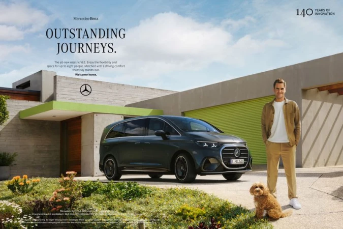 Mercedes-Benz electric VLE minivan, Roger Federer, and dog in front of a modern house with green lawn and partly cloudy sky in daytime.