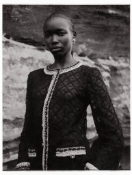 Model Amam Abit wearing a dark textured jacket against a rocky outdoor background for Blanc Magazine.
