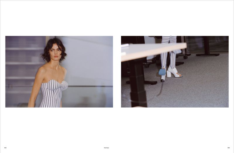 Fashion photo with a slender woman in a striped top standing in an office, and a person wearing striped stockings sitting at a desk.