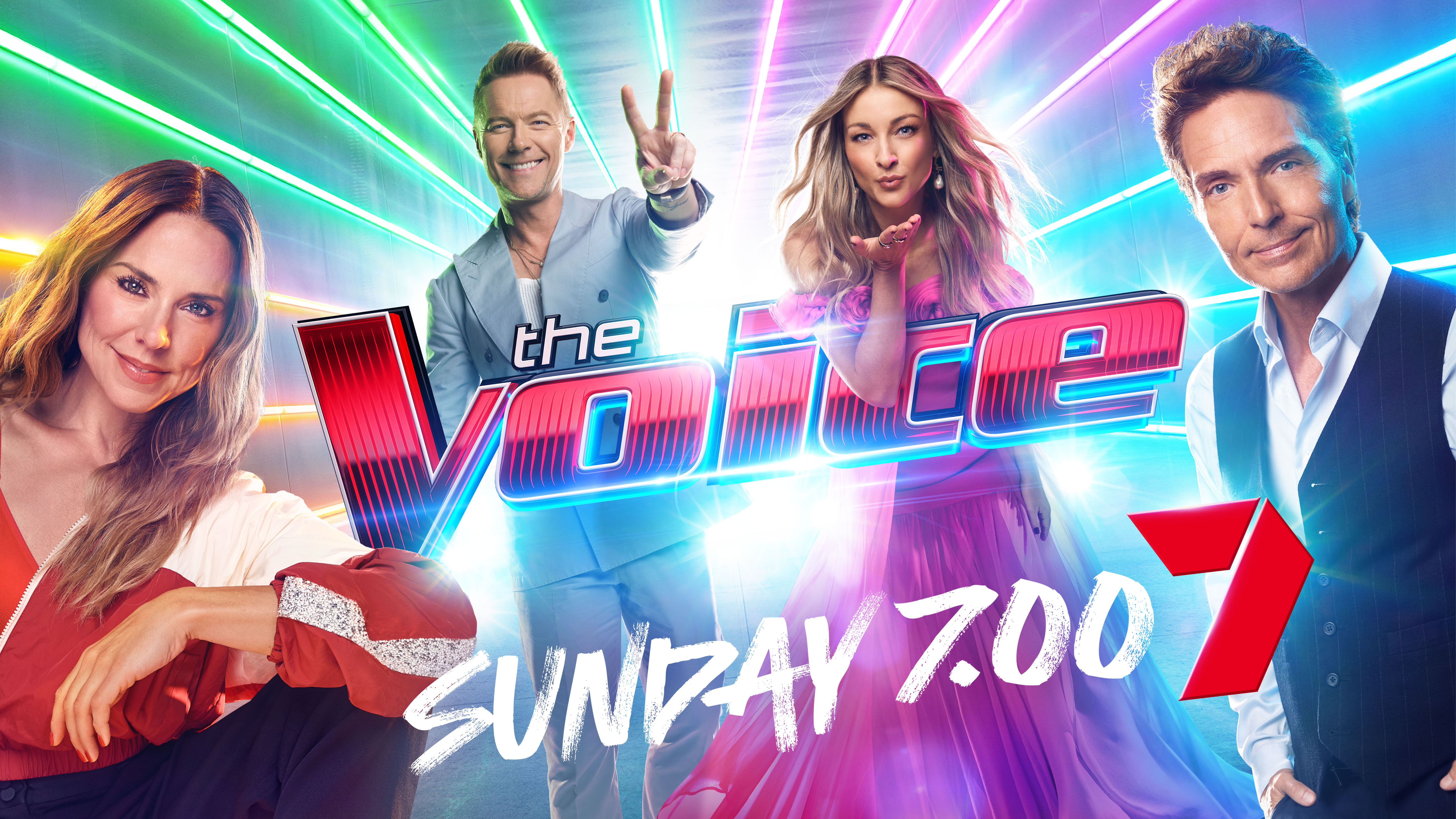 Promotional image for 'The Voice' television show featuring four adult judges in a bright, colorful setting. The show logo is prominent.