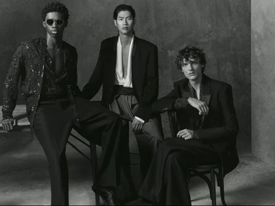 Three male models in black studio attire posing against a dark textured wall for Zara Man Studio Party Collection.