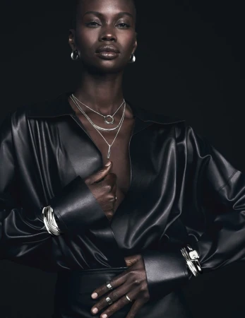 Model wearing a black leather shirt and layered silver necklaces for Movado Curve Collection