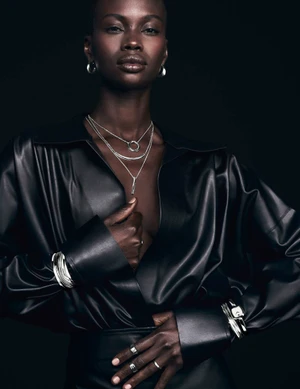 Model wearing a black leather shirt and layered silver necklaces for Movado Curve Collection