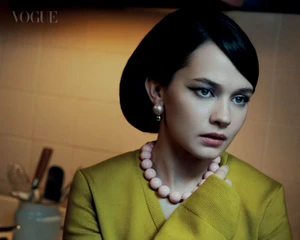 Close-up portrait of actor Cailee Spaeny wearing a yellow top and pink beaded necklace for Vogue Singapore, photographed by Norman Jean Roy.