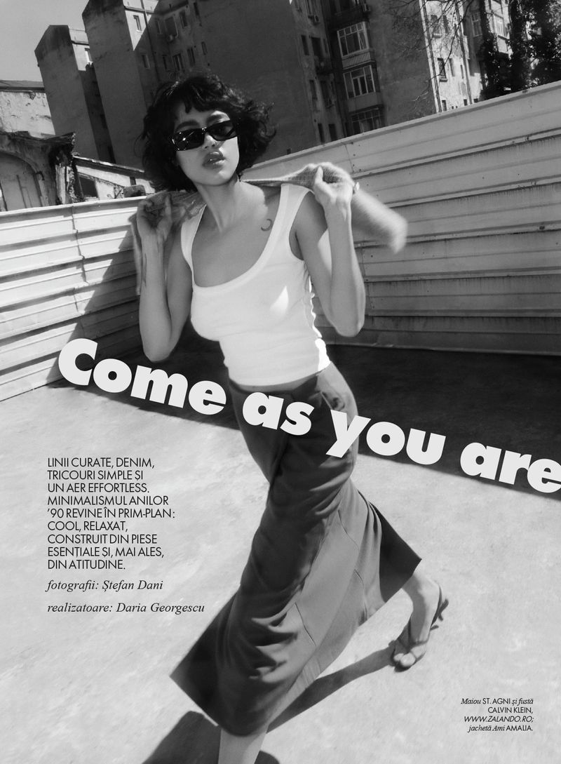 Monochrome fashion editorial image of a woman wearing sunglasses and a white tank top outdoors for Elle Romania.