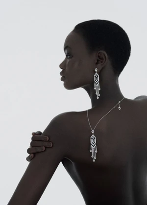 Model wearing diamond drop earrings and necklace against a plain white background for 10 Magazine