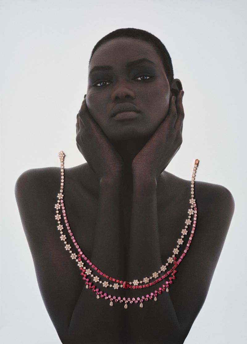 Model Ateta Jok with hands to her face wearing jeweled necklaces for 10 Magazine