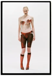 Model standing against a white backdrop wearing red sparkly shorts and knee-high sheer socks with floral motifs