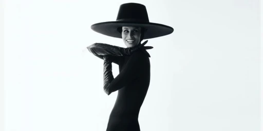 Model Niki Taylor wearing a wide-brimmed black hat and leather gloves against a white background for Elle Canada