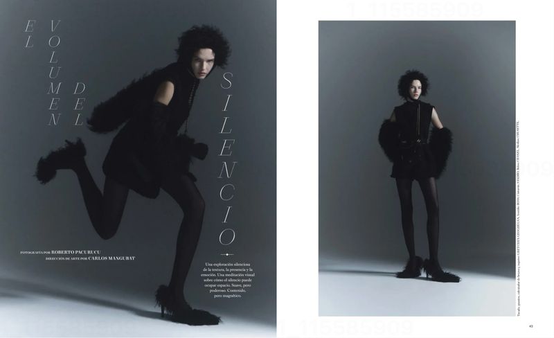 Fashion editorial shot featuring an adult female fashion model with dark, curly hair wearing a black dress with tights in a studio.