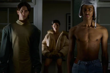 Three male models in dim indoor lighting posing together for Coeval Magazine editorial Duality of durability