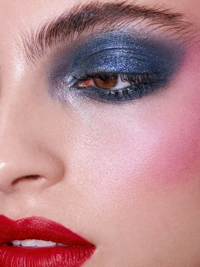 Close-up portrait of a woman with vibrant blue eyeshadow and bright red lipstick for Vogue Portugal Kiss issue