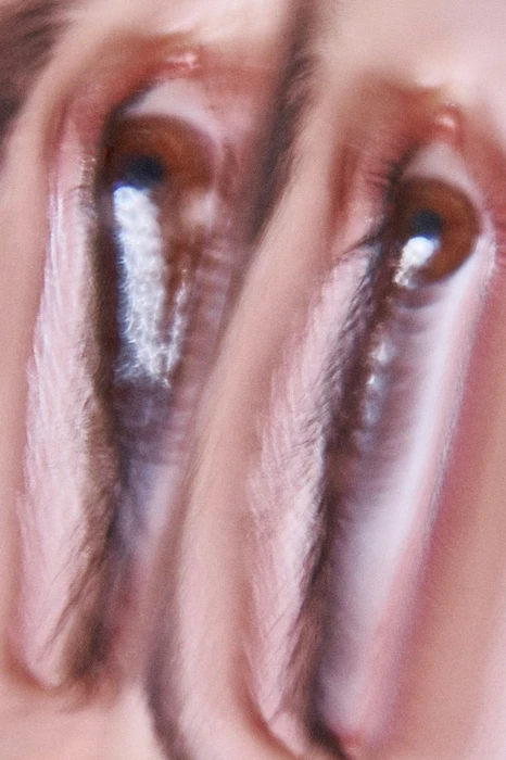 Extreme close-up macro view of two brown eyes with blurred, distorted multiple-exposure effect in Vogue Portugal Kiss issue editorial.