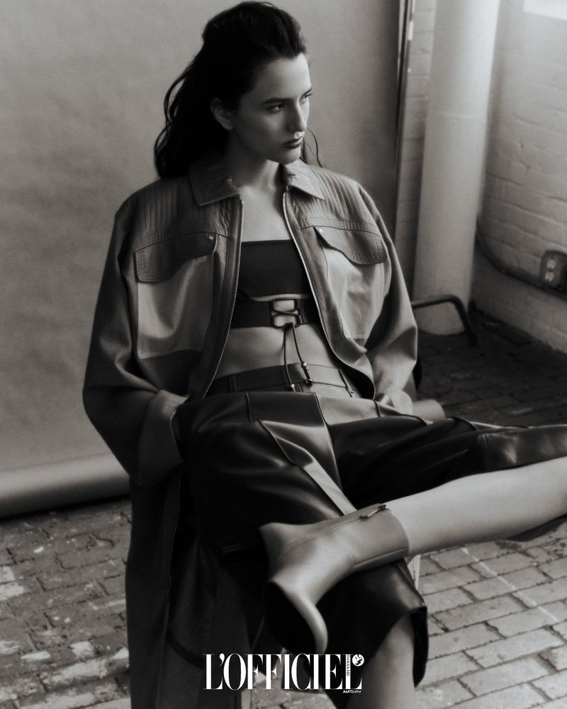 Model wearing a leather jacket and boots seated in an industrial interior for L'Officiel Thailand