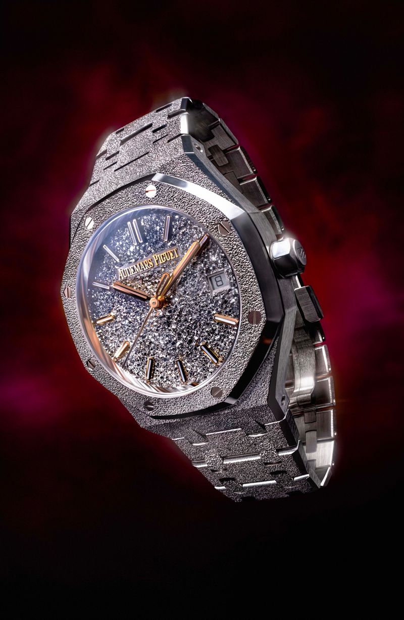 Close-up of a grey Audemars Piguet Royal Oak Frosted Gold watch on a dark background, emphasizing its textured finish and luxurious design.
