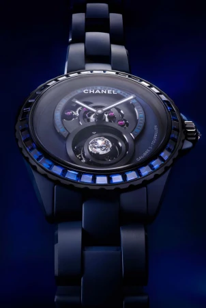 Elegant navy blue Chanel watch features a dark face, transparent inner mechanisms, sapphire embellishments, and a linked ceramic band.