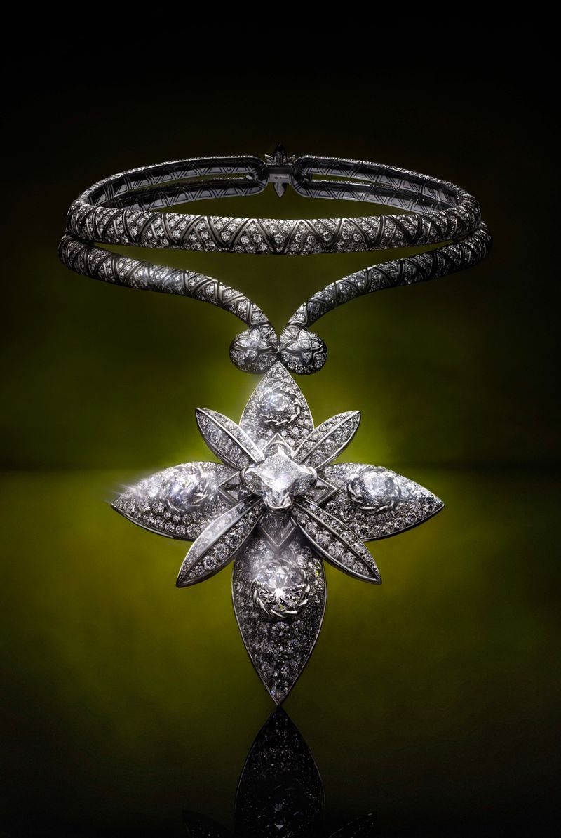 Elegant diamond necklace featuring a floral pendant design, shimmering against a gradient green to black backdrop in a studio setting.