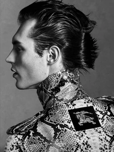 Profile portrait of male model Kit Butler wearing a snakeskin print jacket for V Man, photographed by Luigi and Iango.
