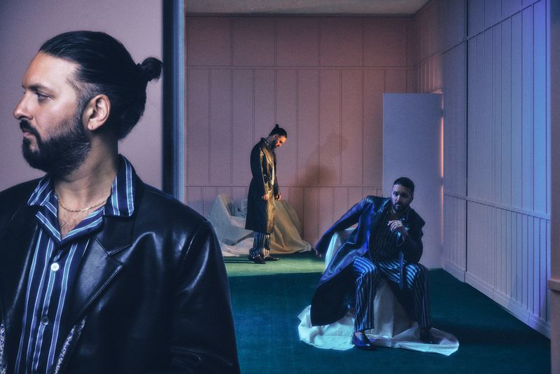 Portrait of three adult men in a room with green floors and paneled walls, wearing stylish jackets and shirts, showcasing modern fashion and posing.