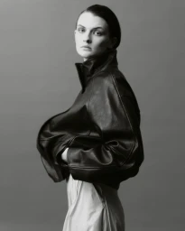 Model wearing a black leather jacket against a grey studio backdrop for Telva magazine