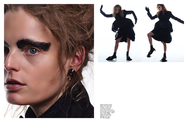Avant-garde fashion shot showcasing a model with dramatic makeup and dark clothing, striking a pose against a bright white background.