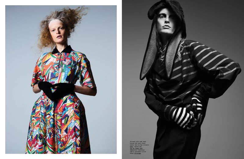 Fashion editorial featuring two models wearing colorful and black and white striped outfits against a grey backdrop, with one in a rabbit hat.