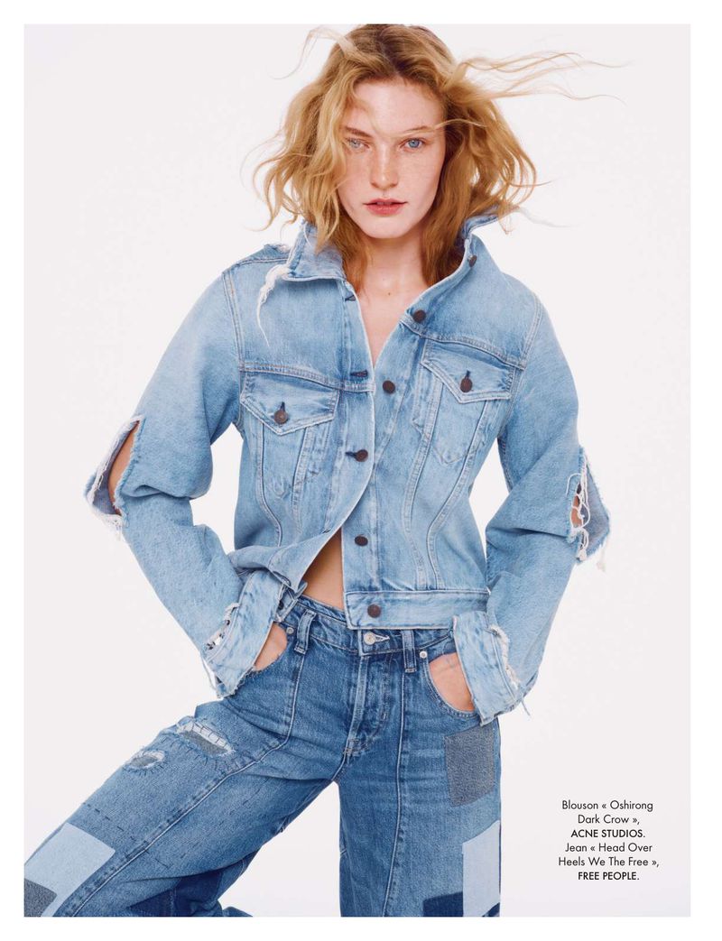 Fashionable woman in light denim jacket and matching jeans against white background, showcasing a casual and trendy denim-on-denim style.