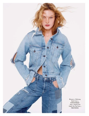 Fashionable woman in light denim jacket and matching jeans against white background, showcasing a casual and trendy denim-on-denim style.